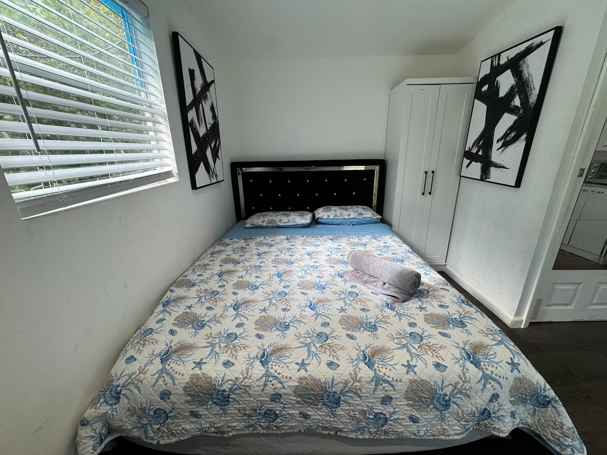 Guest room with a queen bed, tufted headboard and abstract art