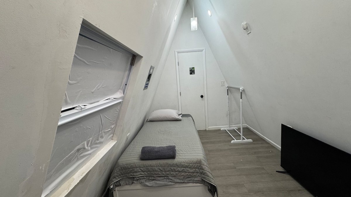 Long view of the narrow loft with bed and window