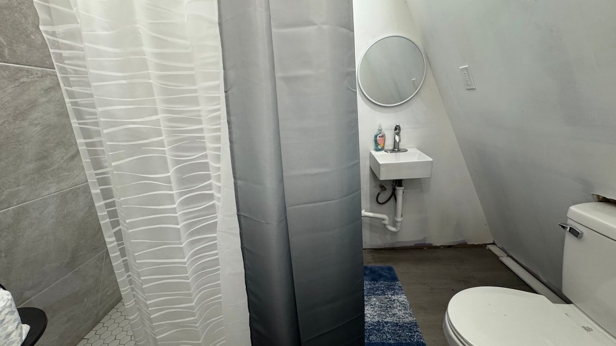 Private bathroom with compact sink, mirror and toilet