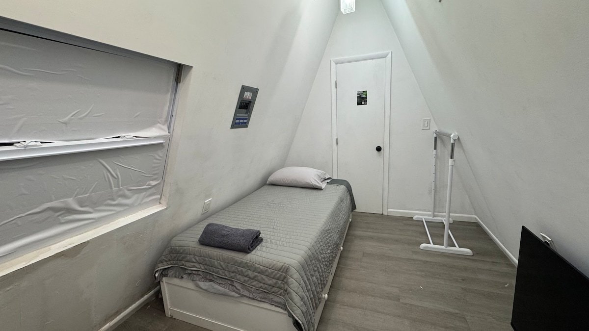 Narrow Walled Loft with a twin bed under a slanted A-frame wall