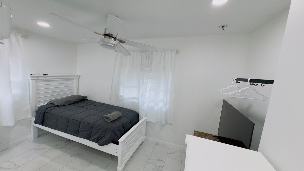 Studio room with bed, ceiling fan and closet rail