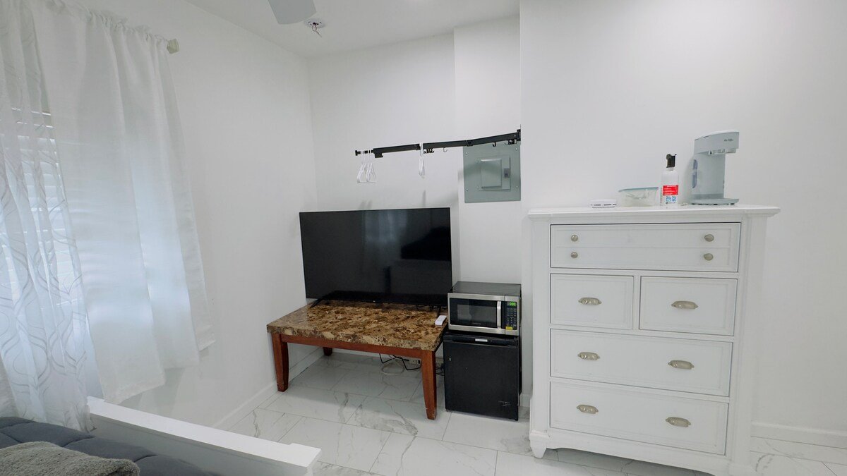 Dresser, TV, mini fridge and coffee maker in the studio