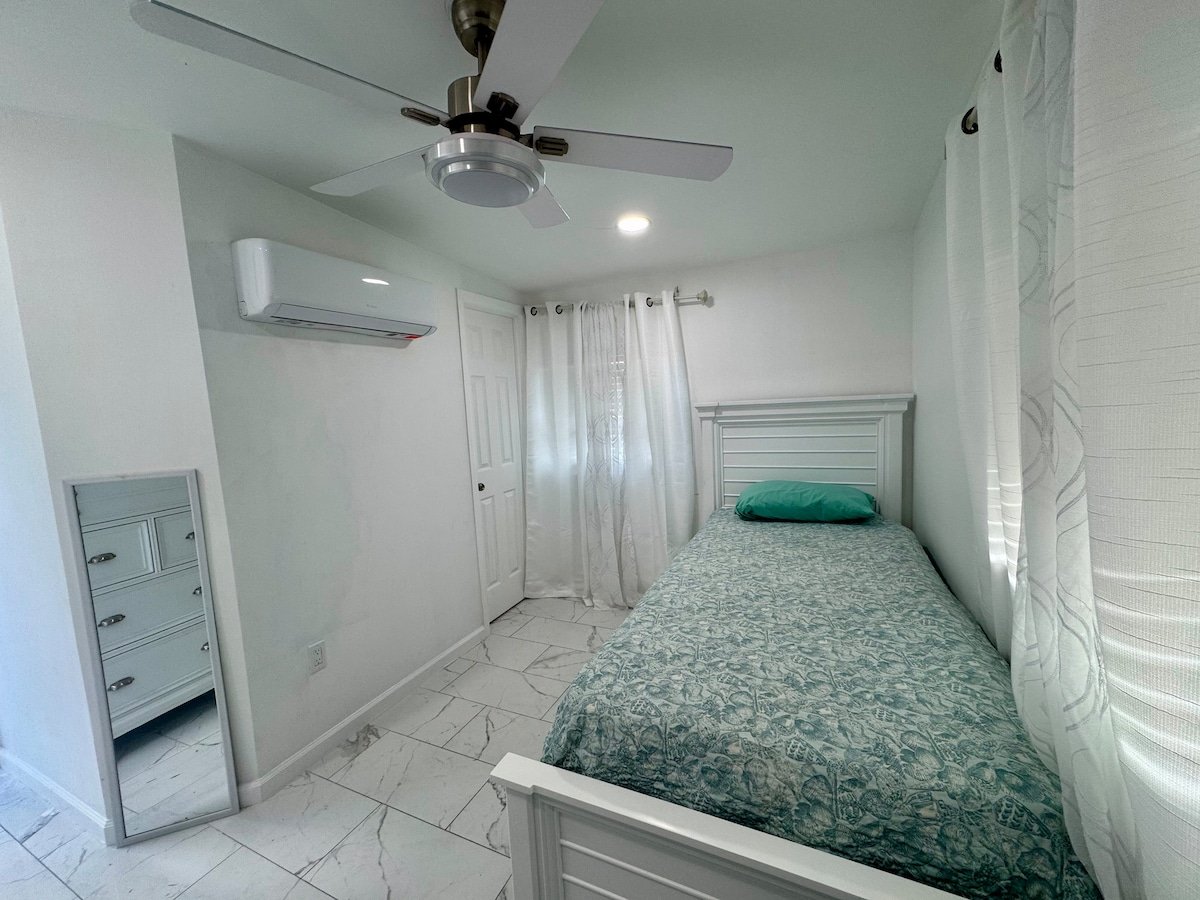 Studio room with bed, mirror and split AC unit