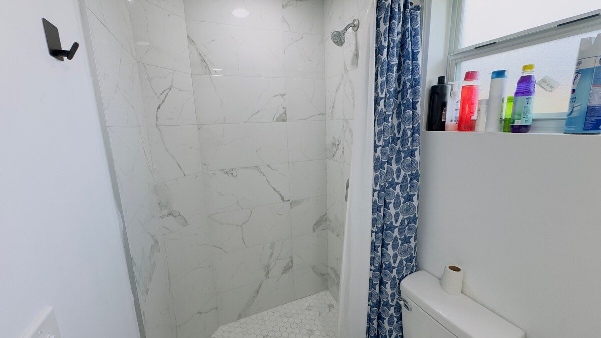 Marble-look walk-in shower with toiletries