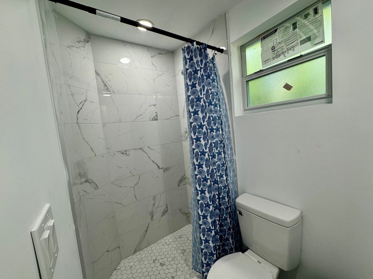 Walk-in shower with curtain and window