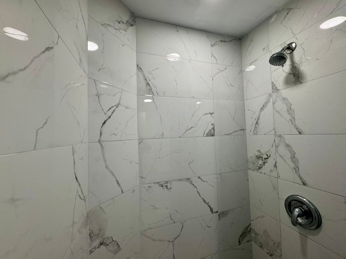 Marble-tiled shower with rainfall-style head