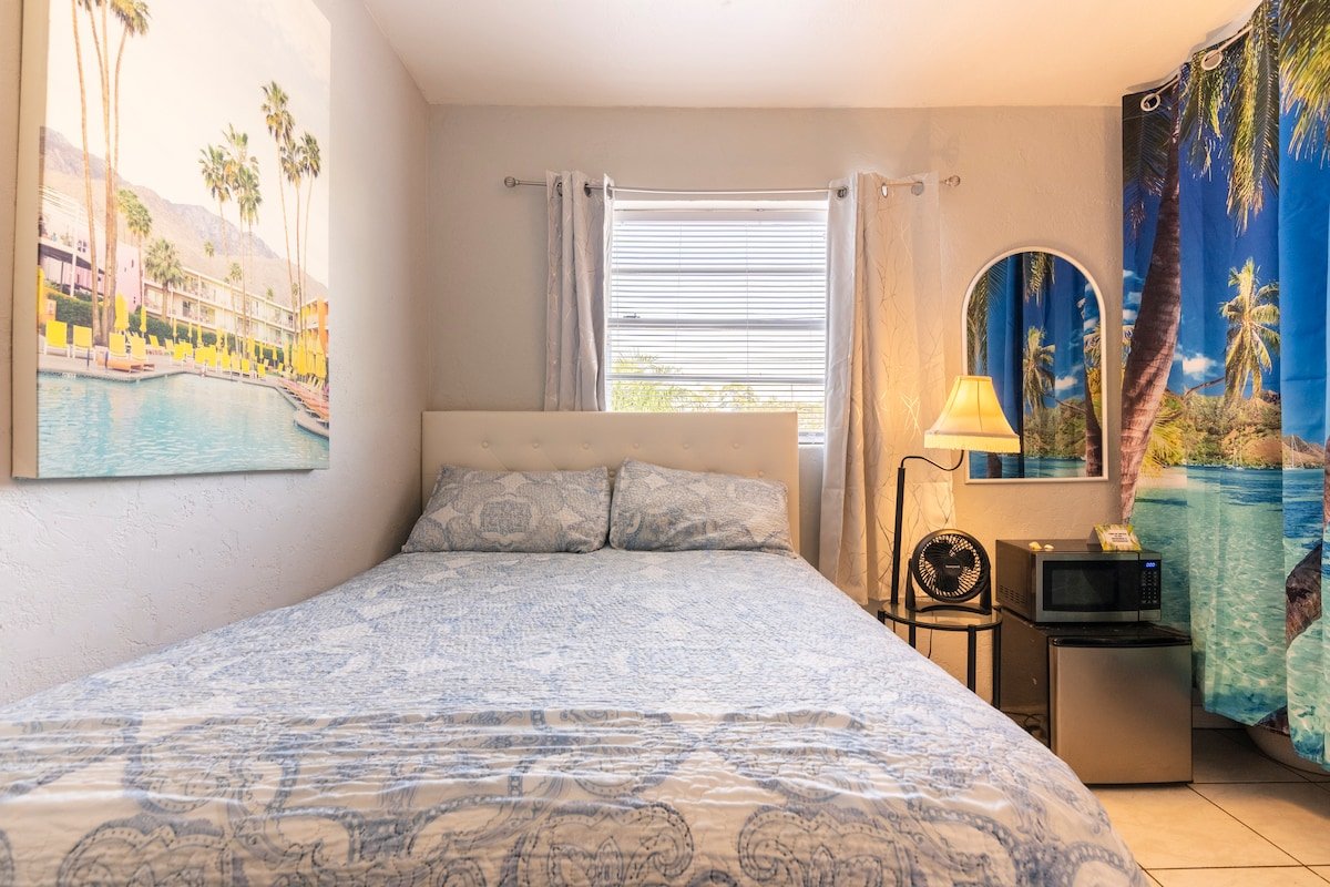 Room West bed with palm-themed wall art