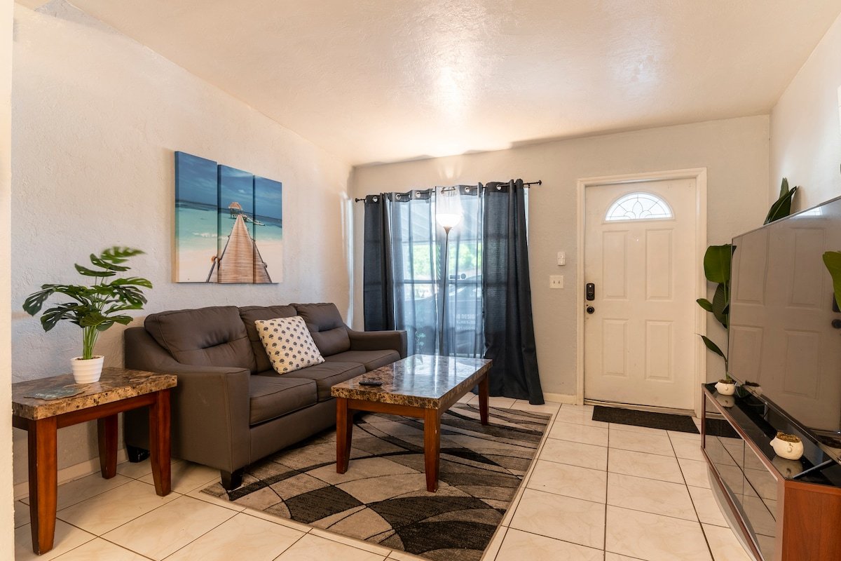 Shared living room with sofa, coffee table and front window