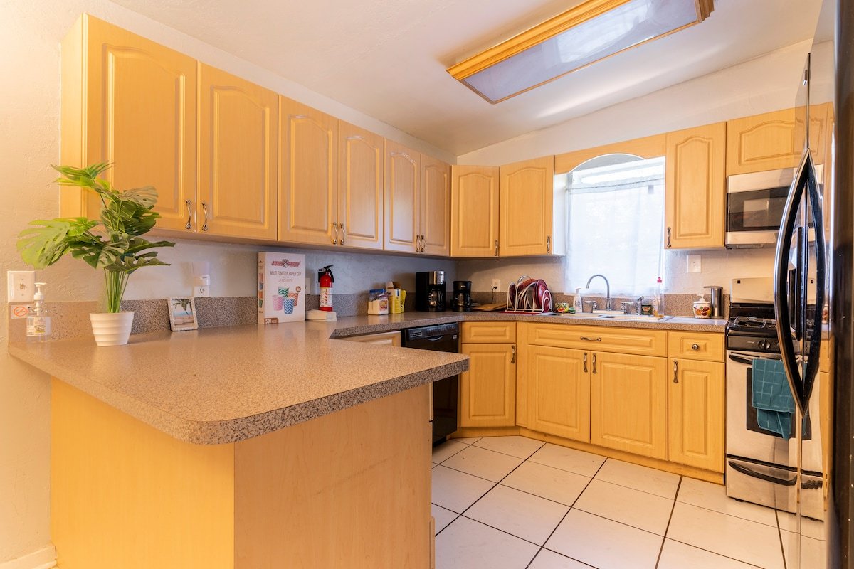 Shared kitchen with peninsula counter and wood cabinets